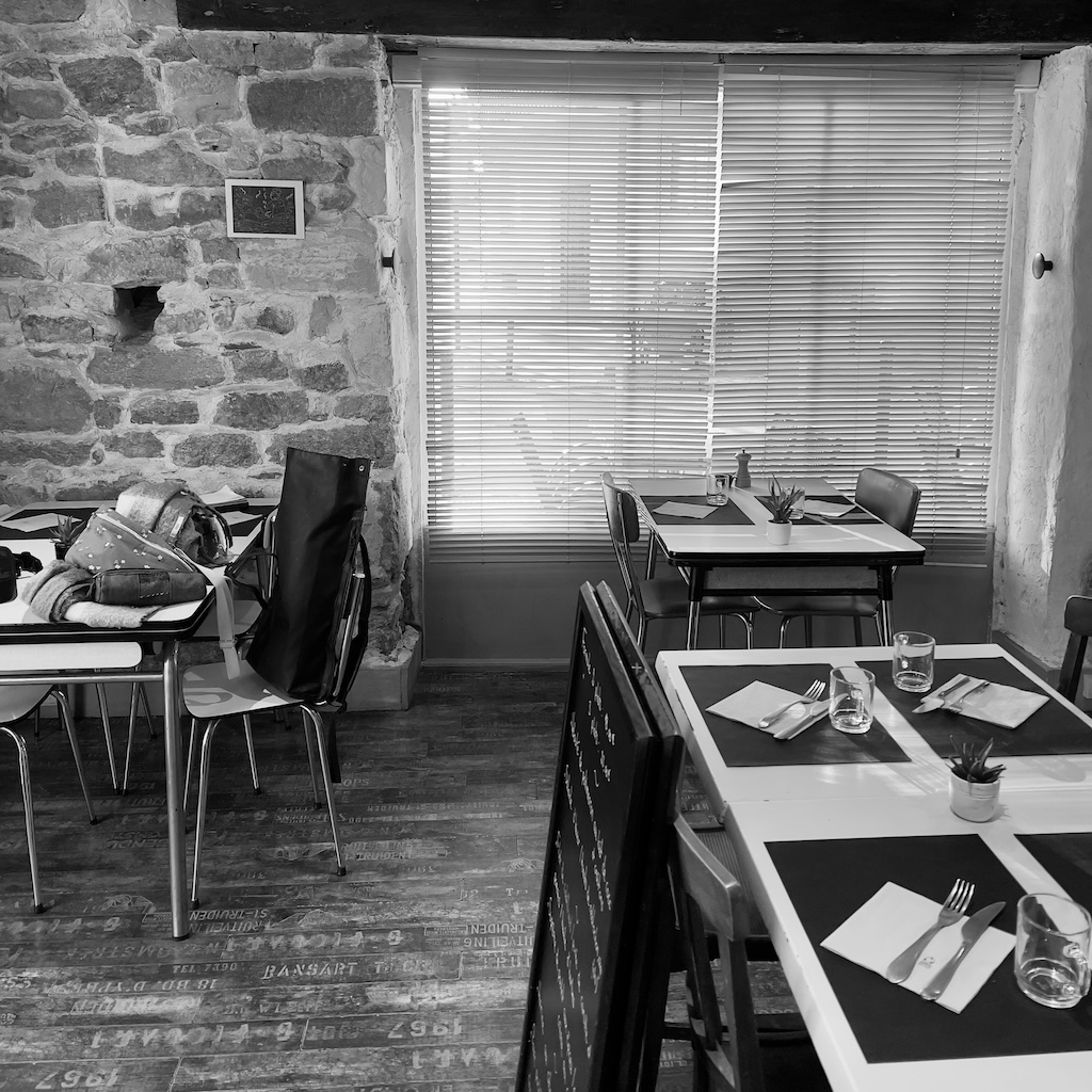 Ancienne salle de restaurant avec mobilier en formica et décoration datée