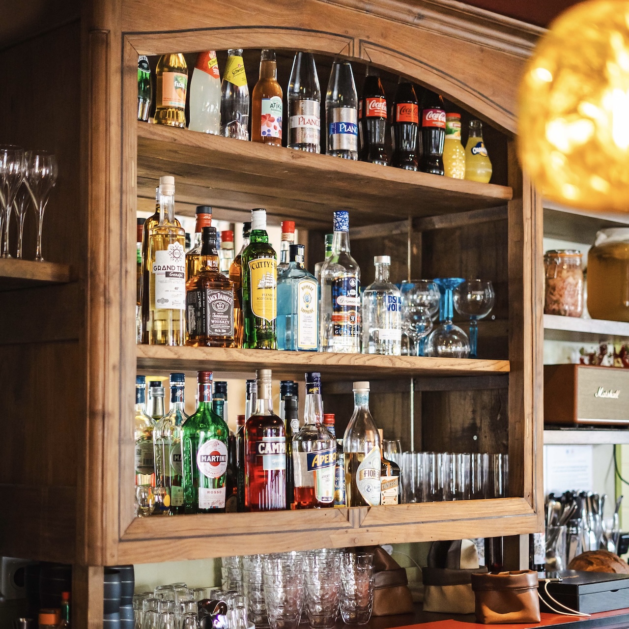Détail de l’arrière-bar en bois récupéré avec miroir ancien et tablette, pour le restaurant MEIGA