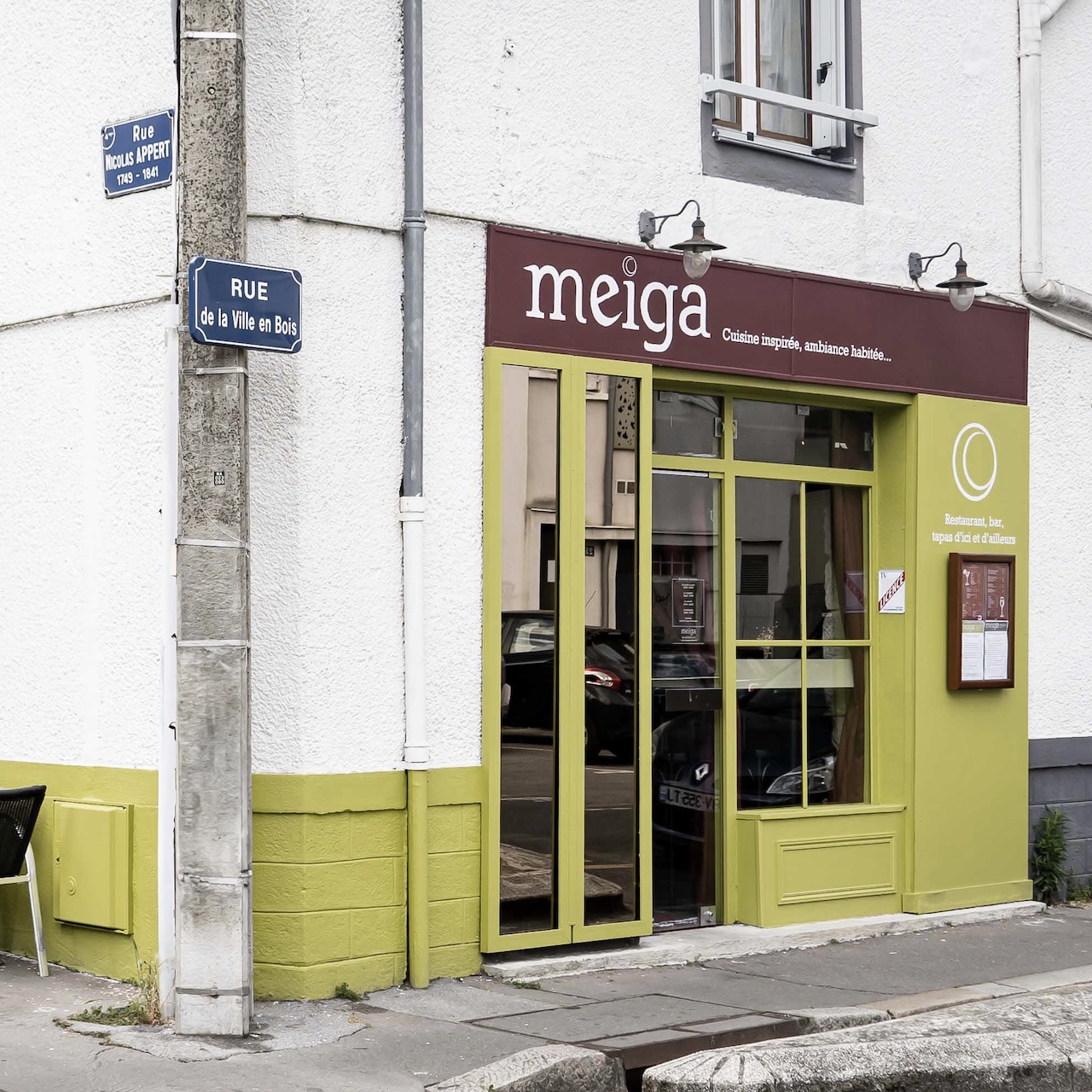 Façade du restaurant MEIGA avec une palette de verts et bordeaux et des enseignes peintes à la main