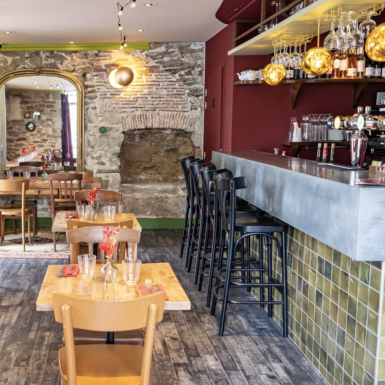 Mobilier ancien chiné avec un bar en faïence en arrière-plan, créant une atmosphère chaleureuse