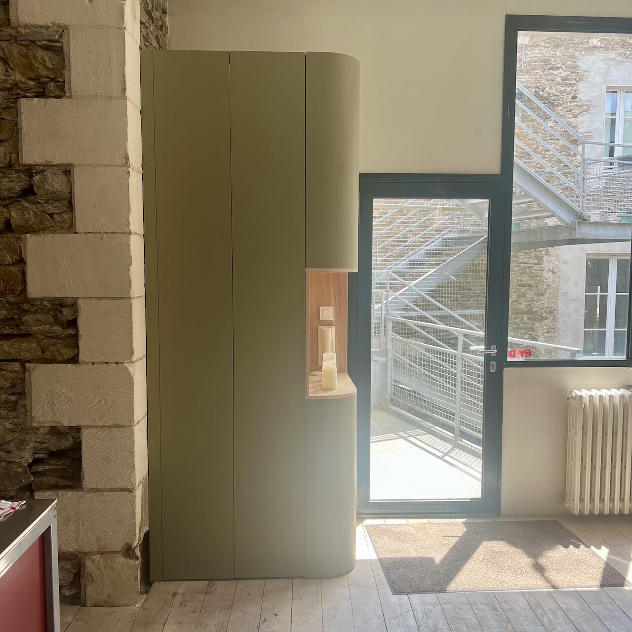 Meuble d’entrée en stratifié avec rangements intégrés, formes arrondies et dissimulation des zones techniques dans un loft à Nantes