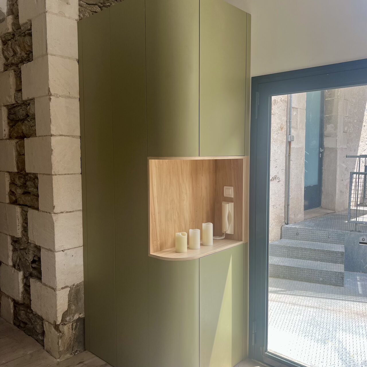 Meuble d’entrée en stratifié avec rangements intégrés, formes arrondies et dissimulation des zones techniques dans un loft à Nantes