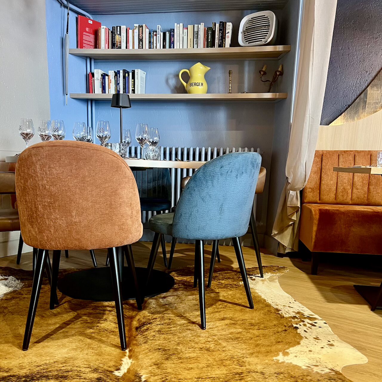 Vue du coin table ronde près de la bibliothèque, offrant un espace cosy et intime