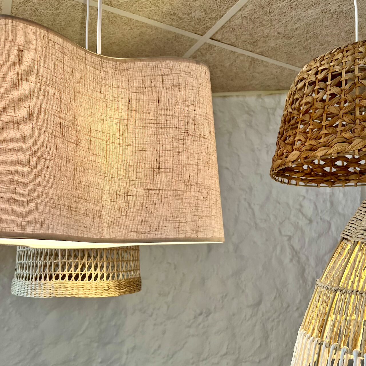 Zoom sur les textures naturelles des matériaux et suspensions chaleureuses dans la salle haute