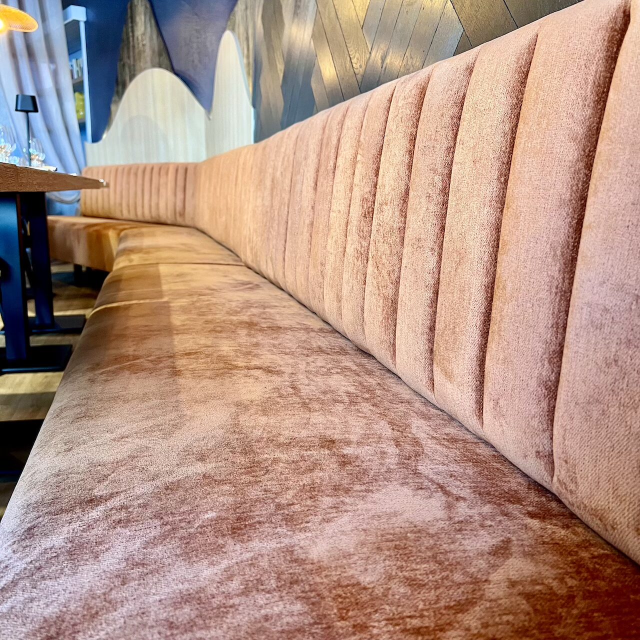 Banquette en velours terracotta offrant une assise confortable dans l’espace restaurant