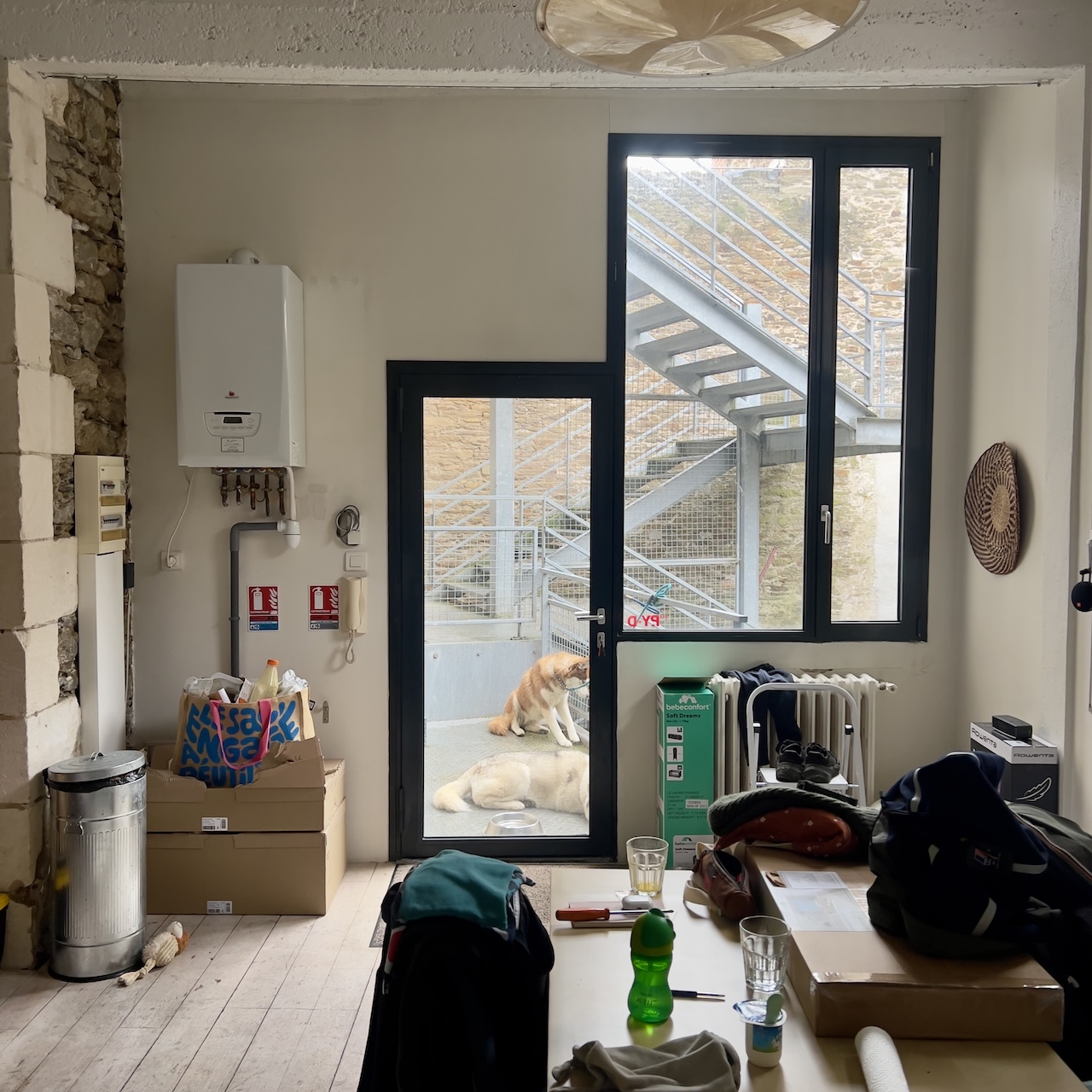 Entrée d’un loft à Nantes avant aménagement, avec disjoncteur apparent, chaudière et aucun rangement