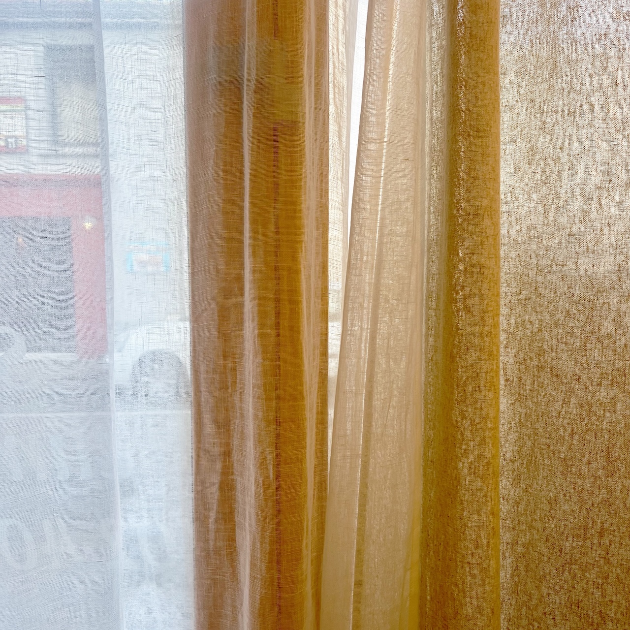 Vue des rideaux du restaurant, mélange de rideaux naturels et de voiles, filtrant la lumière et créant une ambiance douce.