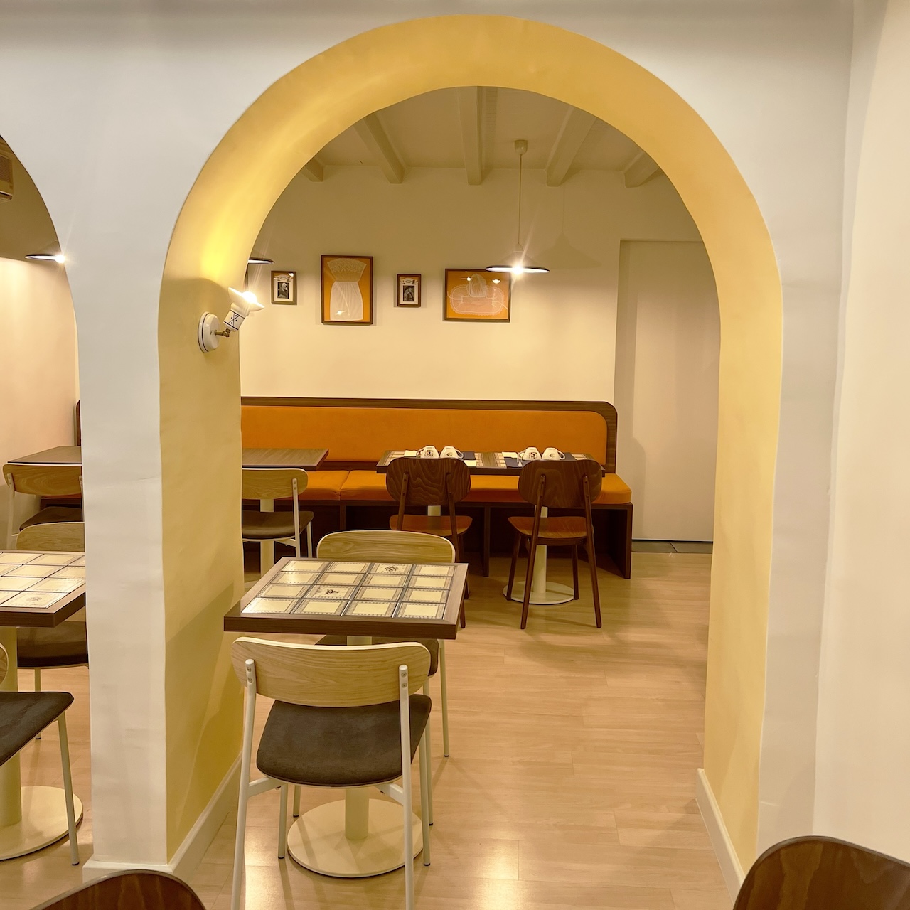 Vue entre les arches vers la salle du fond et sa banquette mandarine