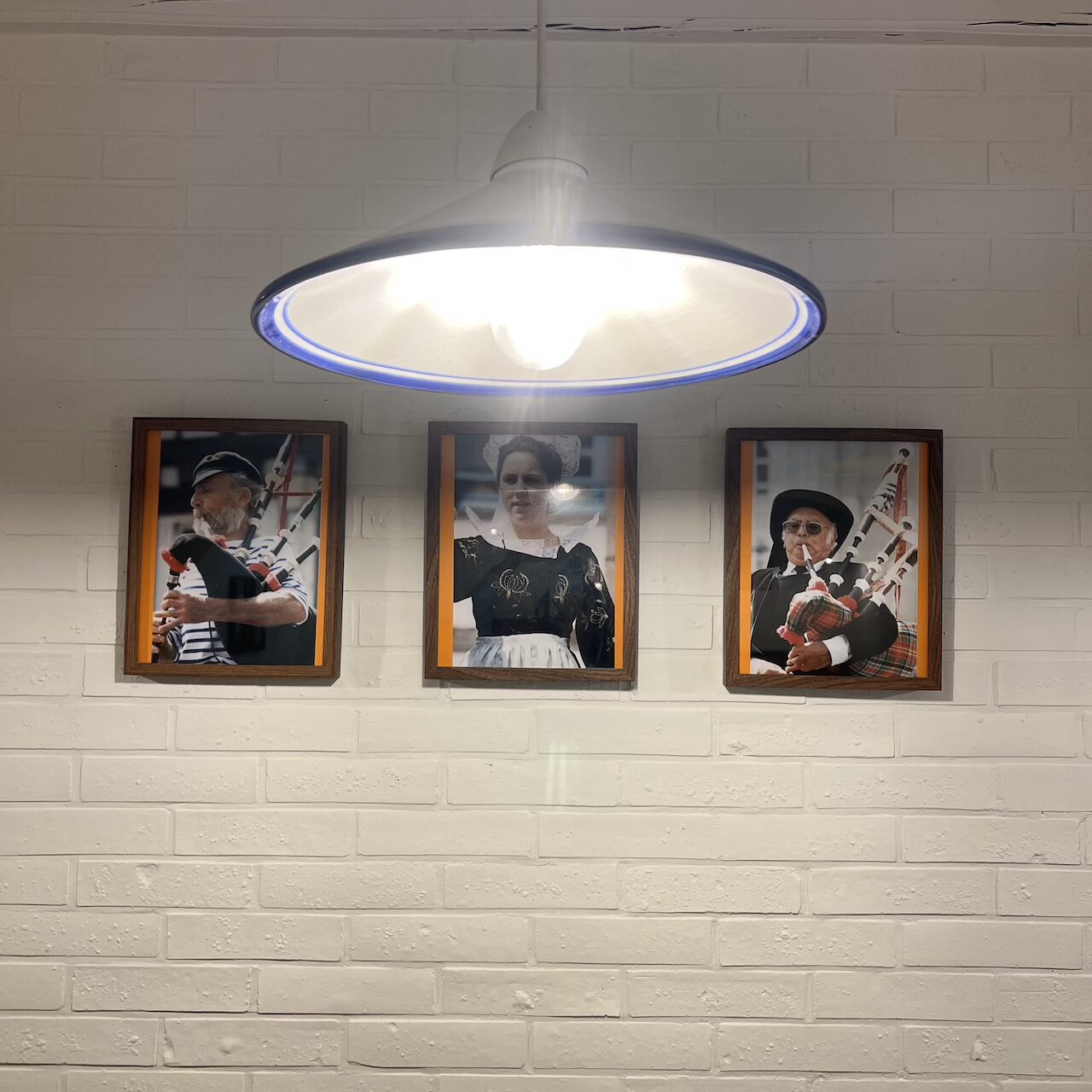 Suspension en céramique bleu et blanche, mise en scène au-dessus des cadres dans une ambiance bretonne.