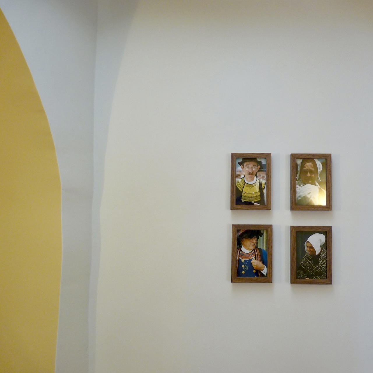 Vue d’une petite partie du restaurant entre quatre arches, avec un plafonnier en bois diffusant une lumière douce et mettant en valeur les courbes et ombres.
