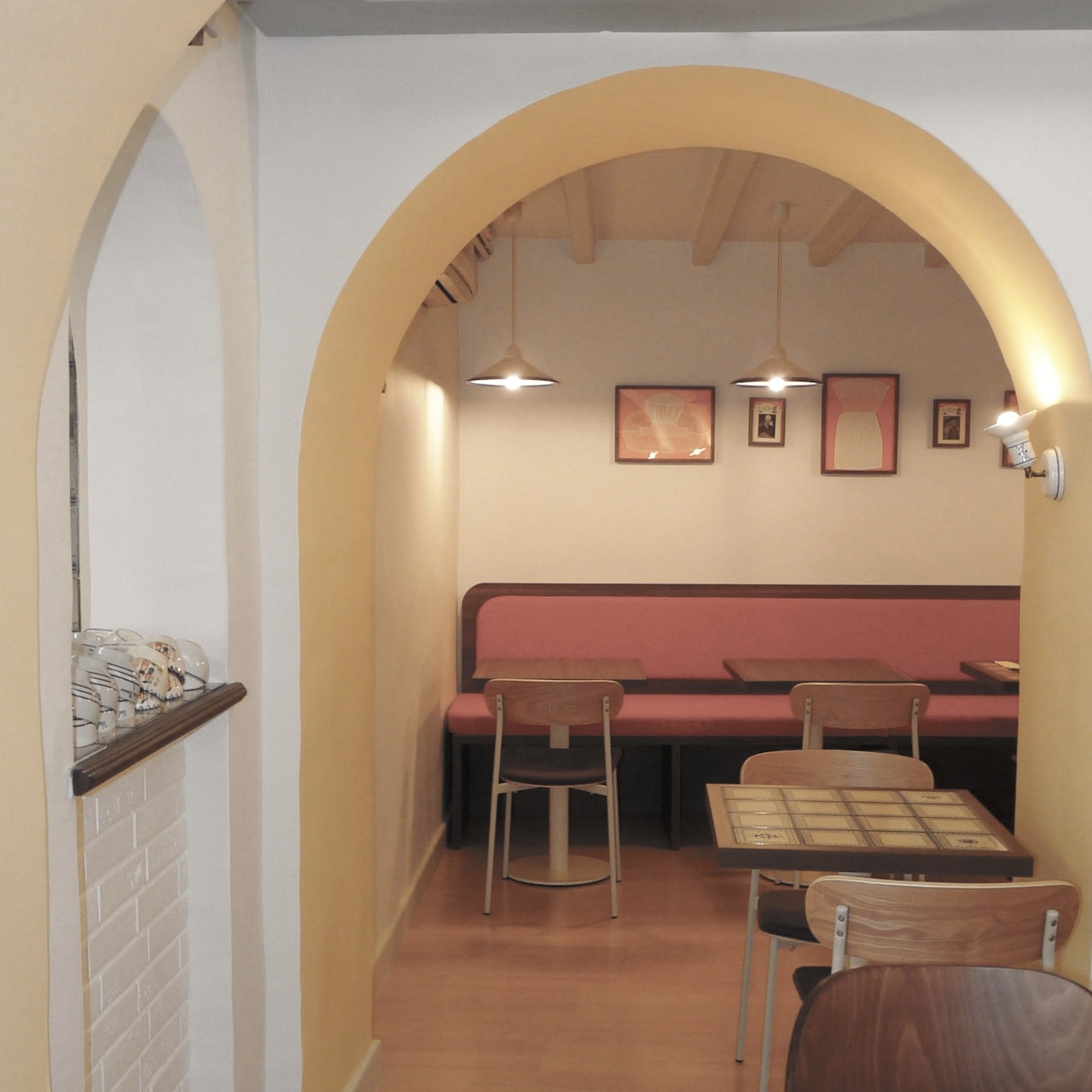 Vue en profondeur vers la salle du fond avec sa banquette mandarine